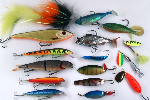 Lures for pike. Left vertical row: Eumer Piketube, Buster Jerk, Nils Master Invincible, Savage Gear 4-Play Herring, Kuusamo Puukala and Rapala Magnum. In the middle: Storm ”Suspi”, Storm WildEye Live Roach, Rapala Minnow Spoon, Turku Spoon, Professor and Krokodil. In the right: Storm, Laxman Spinner, Kuusamo Spinner and Bete Lotto.