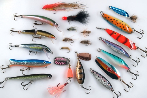 Trout lures for rivers and rapids. Left vertical row: Nils Master Invincible, Rapala Jointed, Rapala Countdown, Nils Master Nirha and LGH Nirha. In the middle: streamer, MA Leech, different kind of dry flies, wet flies and nymphs, Vibrax and Bete Lotto. In the right: Morild, Kopsu, Toby, Trout Quiver, JK-Uistin, Räsänen and EV Trutta.